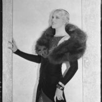 Peggy Hamilton modeling an Earl Luck velvet coat and blue sequin dinner gown, 1931