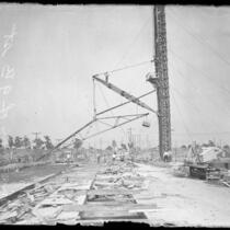 Workmen watching as crane lifts materials during construction of Ninth Street Bridge-viaduct in Los Angeles, Calif., circa 1925