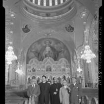 Clergy, civic leaders and artist standing in nave with dome and Iconostasis behind them during opening of St. Sophia Greek Orthodox Cathedral in Los Angeles, 1952