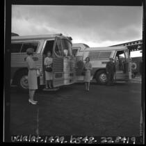 Three female USC alumni boarding buses going to Los Angeles Songfest, 1965