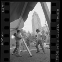 Workers setting up tent for the homeless Tent City, across the street from City Hall in Los Angeles, Calif., 1984