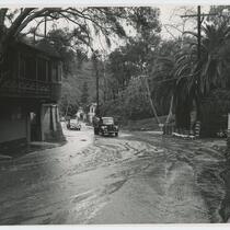 Automobiles drive through the street after flood, Beverly Glen Los Angeles, 1952