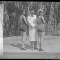 Dr. Charles E. Wood standing between two contestants in the National Chiropractic Association's perfect back contest in Los Angeles, Calif., 1927