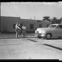 Lt. R. W. Cooley shows new treadles on highway which, when tripped by car operates signal in Santa Monica, Calif., 1948