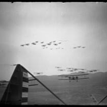Viewed from cockpit of plane, Army Air Corps planes doing aerial maneuvers over California, circa 1930