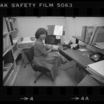Librarian Vivian Arterbery working at terminal of Rand Corp. library's barcode based computer system, 1980