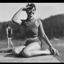 Young woman seated on dock, Lake Arrowhead, 1929