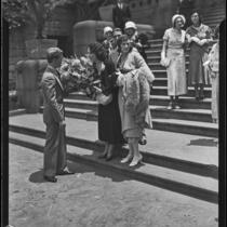 Myrtle St. Pierre, breach of promise plaintiff, holding a bouquet on the steps of the County Courthouse, Los Angeles, 1932