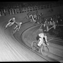 Cyclists compete in a six-day bicycle race at Pan-Pacific Auditorium, Los Angeles, 1937