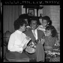 Actor Greg Morris surrounded by his family, holding his Television Father of the Year award, 1971