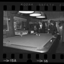 Actor Ryan O'Neal playing pool with three ladies at the Playboy Mansion in Los Angeles, Calif., 1971