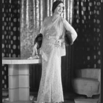 Actress Juliette Compton modeling a lace evening gown and jacket from the Walter Switzer Fashion Salon, 1932