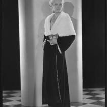 Peggy Hamilton modeling a full length velvet coat with a cape collar in fur, circa 1931-1933