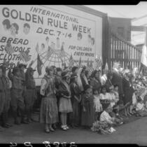 William Gibbs McAdoo and group posing with billboard advertising Golden Rule Week at Golden Rule Foundation Pageant, Los Angeles, 1930