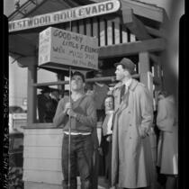 Actor Jimmy Stewart induction in United States Army; standing at Westwood train depot with man holding sign 