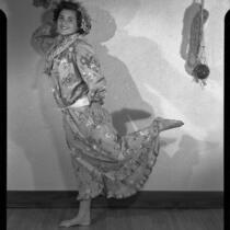 Young woman dancing in a muumuu and palm-frond hat, 1951