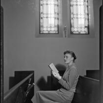 Miriam Braun, sits in a church, 1949