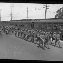 160th Infantry of California National Guard marching besides train in Los Angeles, Calif., 1924