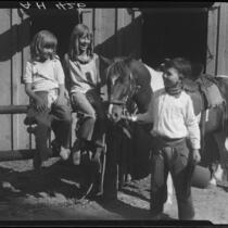 Child rodeo perfomer Little Buck Dale and two girls, Lake Arrowhead rodeo, Lake Arrowhead, 1929