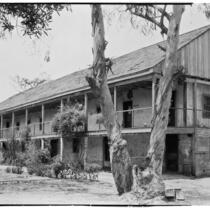 Rancho Los Cerritos, side view from east of decaying house, balcony, walkway, and car, Long Beach, 1930