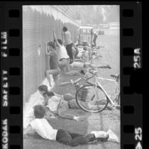 Youngsters and adults watching through chain-link fence at Los Angeles Rams training camp in Fullerton, Calif., 1973