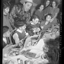 Actor Leo Carrillo hosting Thanksgiving dinner for Mexican American children at La Golondrina restaurant in Los Angeles, Calif., 1937