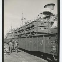 Men and dock workers walking along docked ship, San Pedro Harbor, February 23, 1945