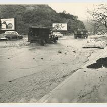 Automobiles drive through floodwaters, Beverly Glen, Los Angeles, February, 1952