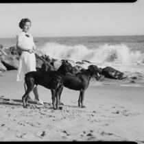 Ruth Bertrand on beach with dogs, Long Beach, 1940