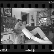 Actor Rock Hudson lounging on couch at his home in Los Angeles, Calif., 1974