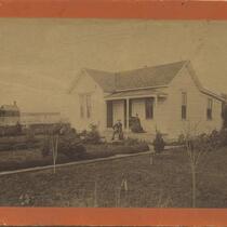 Couple poses in front of house on the corner of 8th Street and Valencia Street, circa 1883.