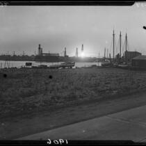 Harbor, oil well drilling rigs, boats, and buildings at sunset, Newport Beach, Laguna Beach, or Long Beach, 1929