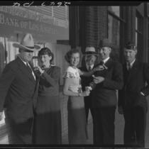 Women pinning boutonnieres on men, 1936