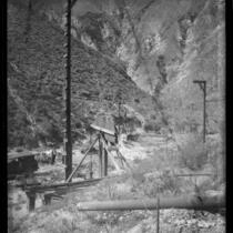 William Mulholland (possibly) in mountain ravine with water pipe construction, California, between 1905 and 1928