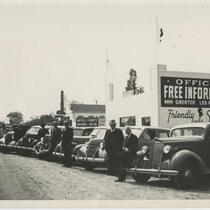 Men and automobiles in front of the Free Information building, 1313 E Garvey Ave., Los Angeles