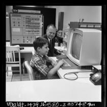 Dr. Robert A. Hayes and his son Robert D. Hayes II at computer terminals, Los Angeles, Calif., 1966