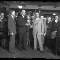 Rex B. Goodcell handing a ring to new Los Angeles, Calif. Internal Revenue collector, Galen H. Welch in 1926