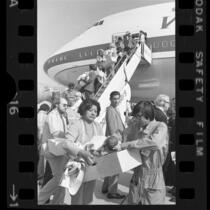 South Vietnamese and Cambodian orphaned infants being carried in cardboard boxes off plane at Los Angeles International Airport, Calif., 1975