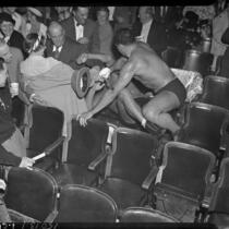 Wrestlers Vincent Lopez and Gino Garibaldi take their fight into the stands at Olympic Auditorium, Los Angeles, 1937