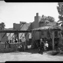 Group of people in front of Pueblo Revival style building, Palm Springs, 1936