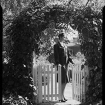 Eleanor Handy at gate with ivy arch, [1940s?]