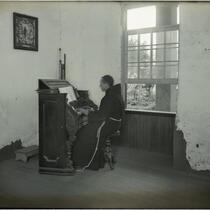 Franciscan Brother Peter playing the organ at Mission Santa Barbara, Santa Barbara, circa 1898-1899