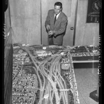 Engineer Heinz Heckeroth points out features on model of Southern California freeways, 1958