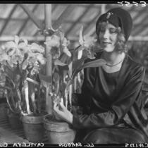 Woman in greenhouse with orchids, Los Angeles, [1931?]