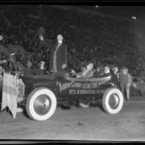 Actor Joe Murphy as Andy Gump, standing in car advertising movie, in Shriners' parade, Los Angeles Coliseum, Los Angeles, 1925