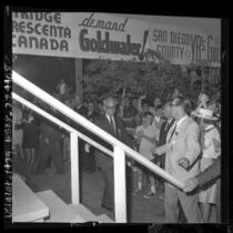 Barry Goldwater surrounded by supporters and banners as he walks towards stage to deliver speech at Knott's Berry Farm, 1964