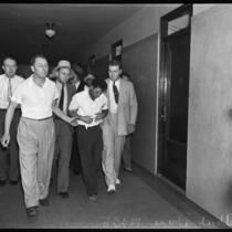 Detectives escorting child murderer Albert Dyer through a hallway, Inglewood, 1937