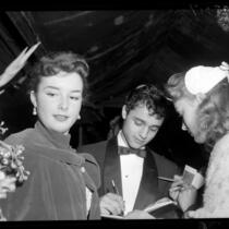 Actor Sal Mineo with actress Gigi Perreau signing autographs at the 1956 premiere of "The Man in the Gray Flannel Suit"