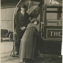 Unidentified man and woman posing on the rear of a train