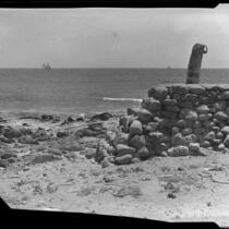 Beach, rock wall, and wooden post, Malibu, 1929